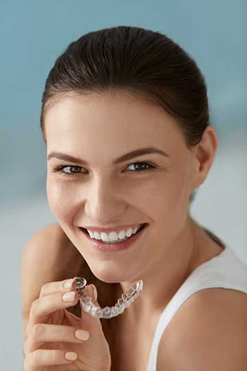 Woman smiling after transforming her smile with Invisalign